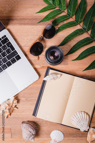 Planning summer holidays, tourism and vacation background. Travelers notebook with accessories on wooden table top view.
