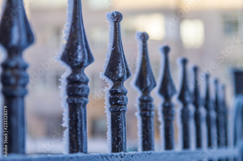 black fence covered with frost