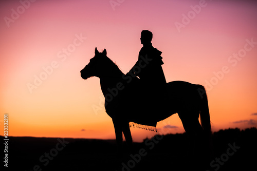 Horses and Men Silhouette at Sunset on a High Mountain