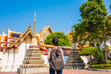 Asian women backpack tourist is relax travel in holiday at wat pho Bangkok Thailand. It is a landmark and attraction.
