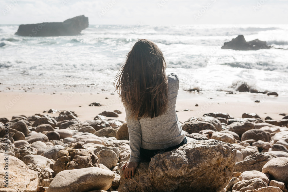 Φωτογραφία The girl in solitude admires a beautiful view of the Atlantic Ocean in Portugal