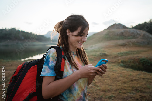 caucasian woman hiker alone enjoy the beauty of nature with smar photo