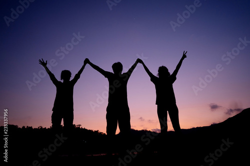 silhouette of camping group hands up together