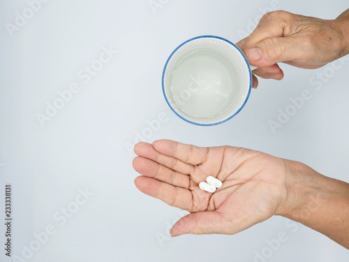 top view of woman holding pill in one hand and glass of water ,Taking Your Medication.