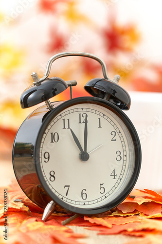 Old clock on autumn leaves