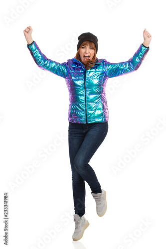 Cheering Young Woman In Vibrant Down Jacket And Cap