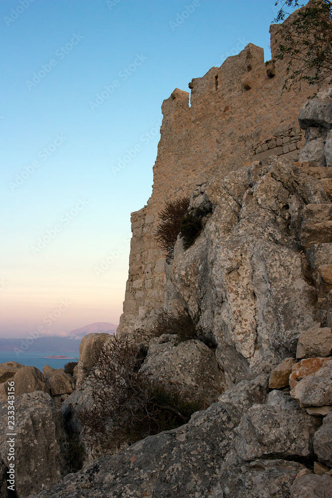 Halki - Castle ruines at sundown located at the peak of the hill. Dodecanese Islands, Greece
