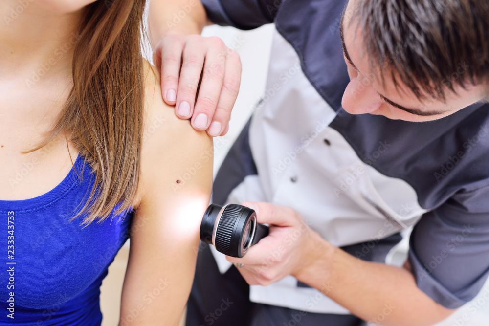 Naklejka premium dermatoscopy-a method of research and diagnosis of skin tumors - moles, birthmarks, nevi, warts, acne with a special optical device Dermatoscope.