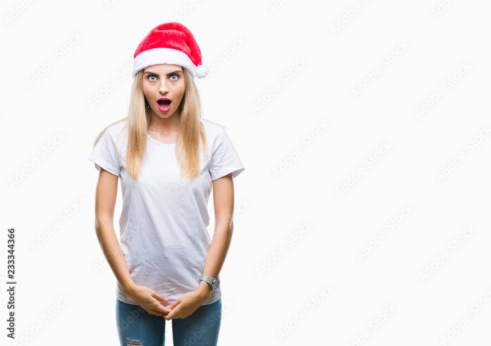Young beautiful blonde woman christmas hat over isolated background afraid and shocked with surprise expression, fear and excited face. Young beautiful blonde woman christmas hat over isolated background afraid and shocked with surprise expression, fear and excited face.