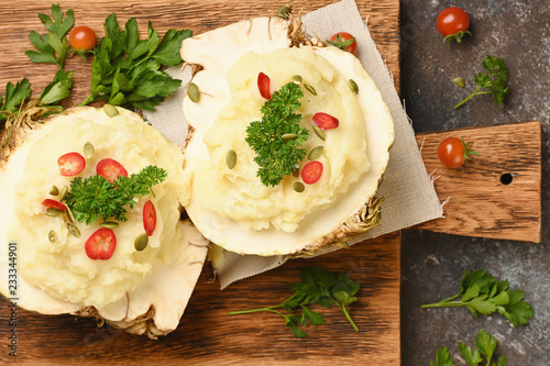 Mashed celery root on wooden cutting board on dark background. Horizontal. photo