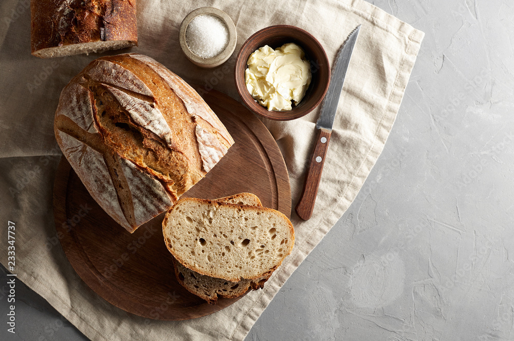 Artisan sliced toast bread with butter and sugar on wooden cutting board