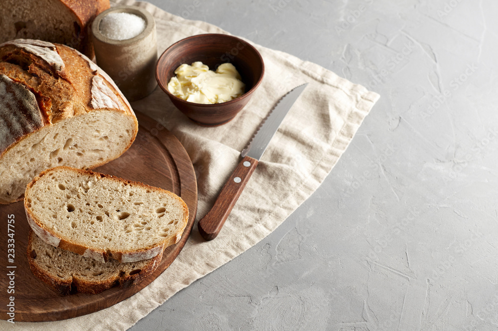 Artisan sliced toast bread with butter and sugar on wooden cutting board