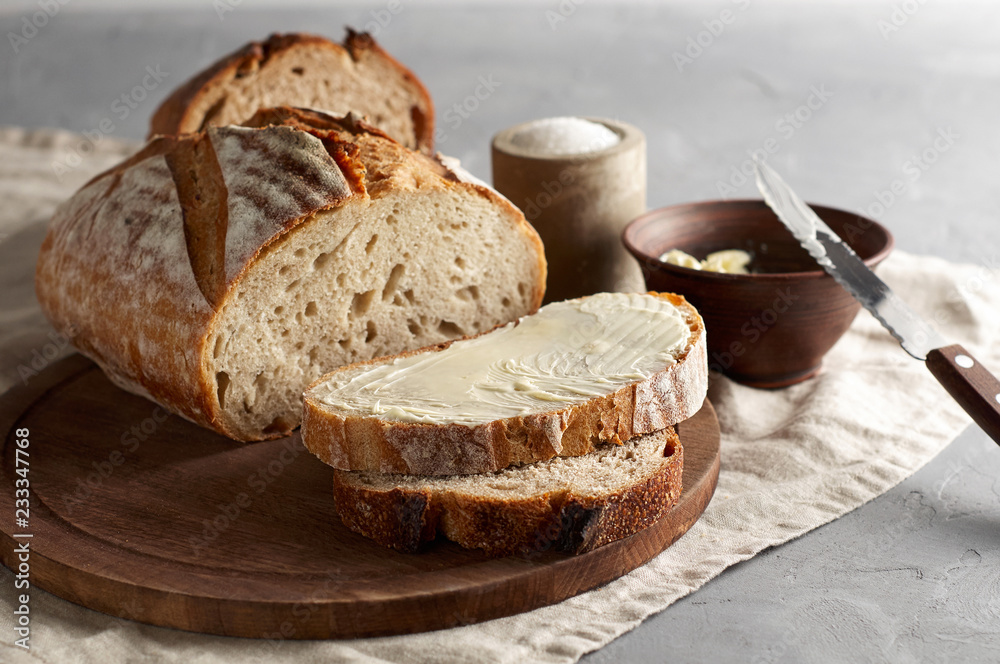Artisan sliced toast bread with butter and sugar on wooden cutting board
