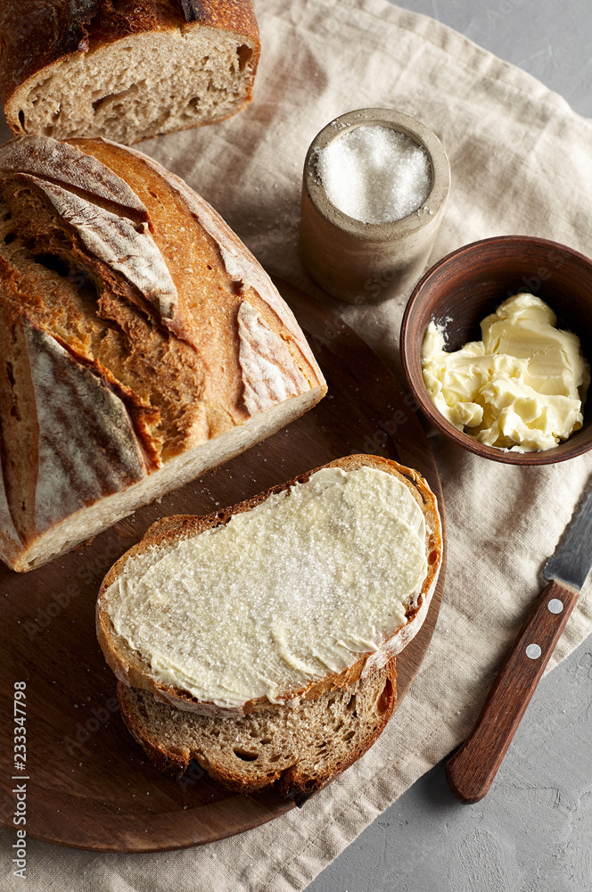 Artisan sliced toast bread with butter and sugar on wooden cutting board