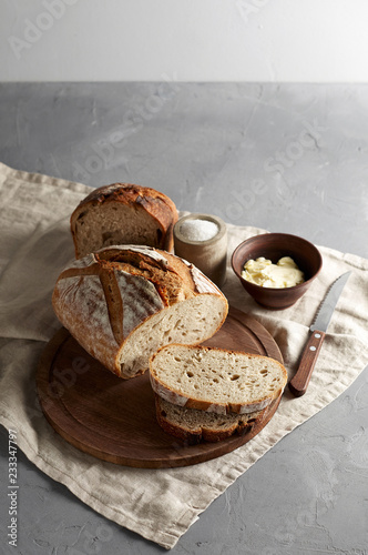 Artisan sliced toast bread with butter and sugar on wooden cutting board