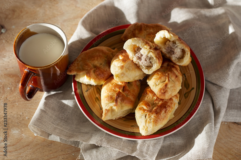 Russian meat piroshki. Traditional hand mini pies on wooden background