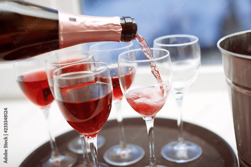 Rose champagne in wineglasses. Champagne is poured into glasses
