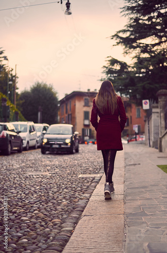 Mujer joven paseando por una calle adoquinada