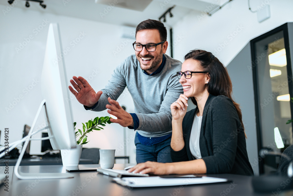 © bnenin - Teawork and success concept. Two business people smiling and looking at computer screen. © bnenin - Teawork and success concept. Two business people smiling and looking at computer screen.
