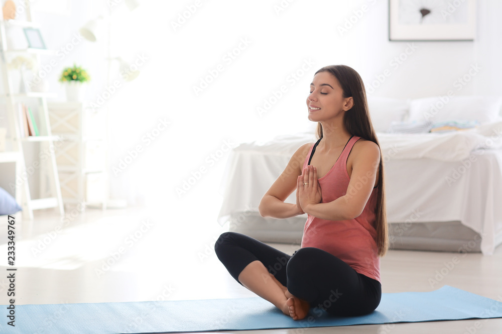 Young pregnant woman practicing yoga at home Young pregnant woman practicing yoga at home