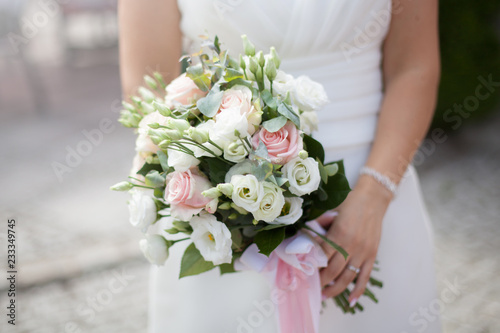 wedding bouquet - pastel flowers in the hands of the bride. Pink, white, cream and jelly kwaites kept by the bride.