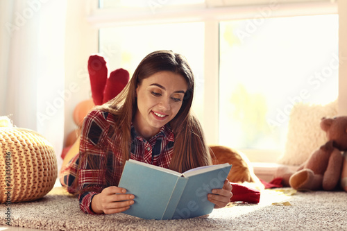 Woman reading book at home ...