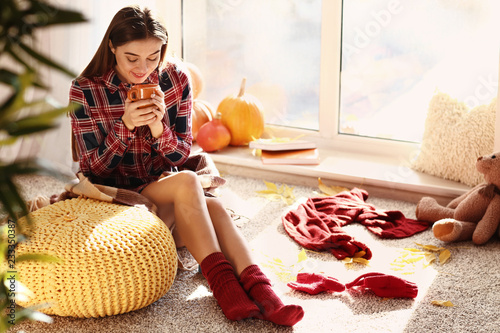 Woman drinking tea while re...