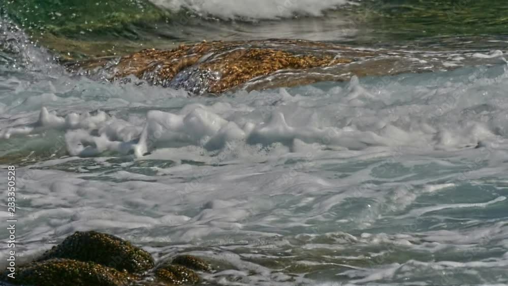 Waves crash on a rock in the sea macro