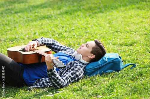 Young man playing guitar wh...