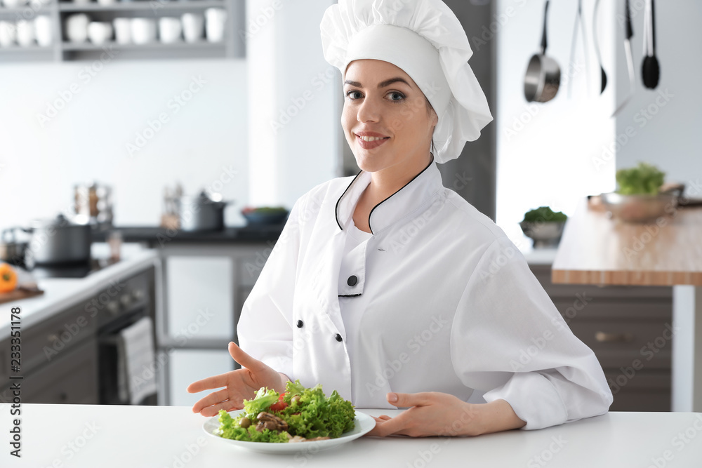 Young female chef with tasty salad in kitchen Young female chef with tasty salad in kitchen