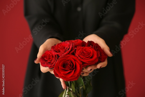 Woman with bouquet of beautiful roses on color background, closeup