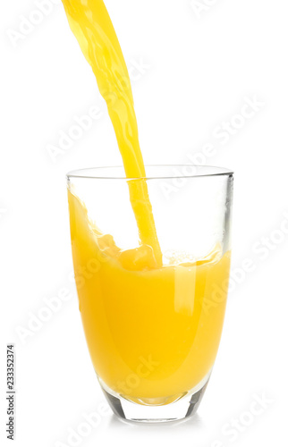 Pouring of orange juice into glass on white background