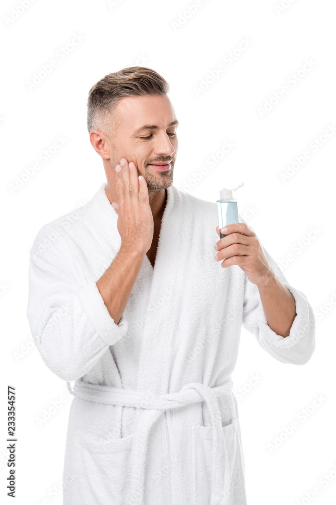 happy handsome adult man in bathrobe using shaving lotion isolated on white happy handsome adult man in bathrobe using shaving lotion isolated on white