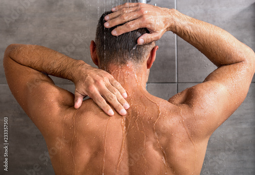 back view of man taking shower in morning at home
