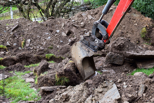 Mini Excavator dug trench in the garden. Works on laying communications.
