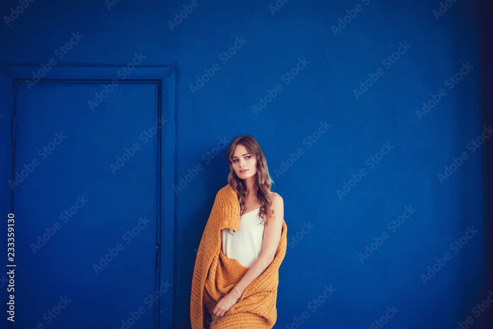 Cozy woman covered with warm wool blanket on blue background. Relax, comfort lifestyle. Cozy woman covered with warm wool blanket on blue background. Relax, comfort lifestyle.