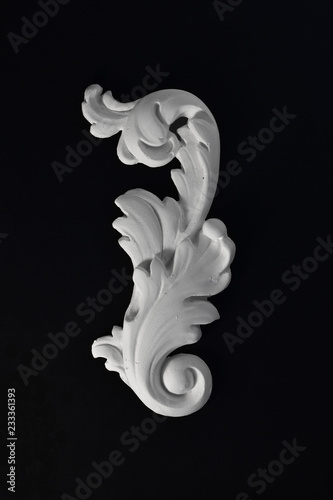 White stucco acanthus leaf on a black background.