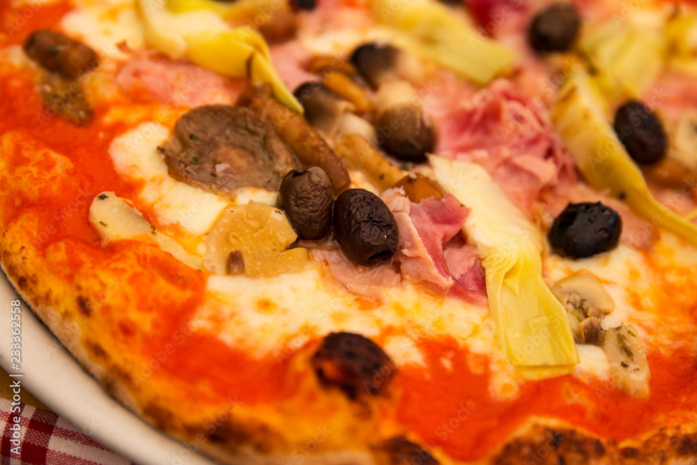 Close up view of a pizza, with olive, ham and artichoke topping Close up view of a pizza, with olive, ham and artichoke topping