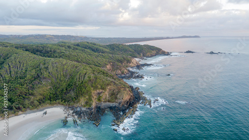 bay beach cliffs and forest at sunrise aerial photo