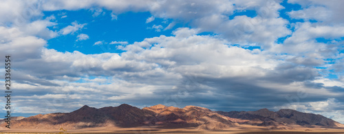 Mountain range panorama of death valley during morning, Storm cloud skies in the distance © Gabriel Cassan