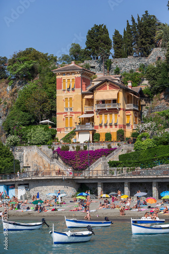 Boats in front of the beach in Levanto, Italy. An inpressive house cloaked in bougainvillea is in the background photo