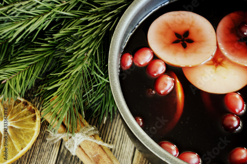Christmas mulled wine with cranberries in a pot Winter warming drink with spices decorated with fir branches cinnamon dried oranges