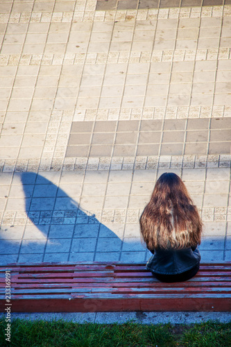 Lonely Girl sitting on a bench waiting for