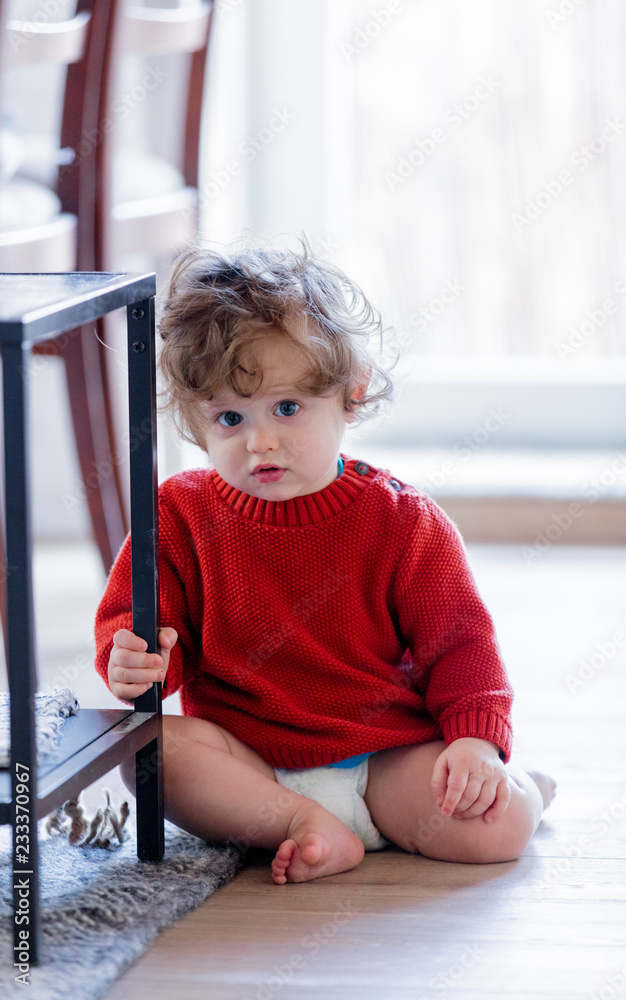 little toddler boy on a floor at home. Wearing in red sweater little toddler boy on a floor at home. Wearing in red sweater