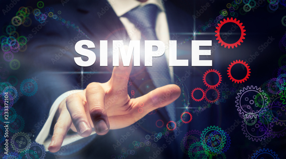 A businessman pressing a Simple business concept on a graphical display of cogs A businessman pressing a Simple business concept on a graphical display of cogs