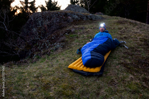 Mann übernachtet draussen auf Isomatte, Gipfel Mittelgebirge übernachten