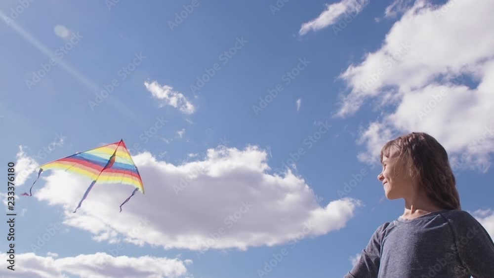 Happy child with a kite. Little girl with a colorful kite on the background of the sky. Happy child with a kite. Little girl with a colorful kite on the background of the sky.