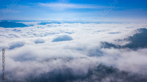 Aerial view above a Sea of fog coverage the mountains in the morning freshness.