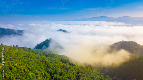 Aerial view above a Sea of fog embrace the mountains in the morning freshness.
