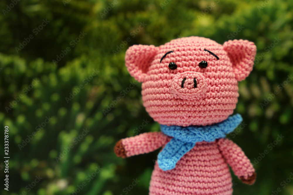 Knitted toy piggy on christmas decorations background. Chinese new year of the Pig, symbol 2019, Zodiac sign for greetings card Knitted toy piggy on christmas decorations background. Chinese new year of the Pig, symbol 2019, Zodiac sign for greetings card